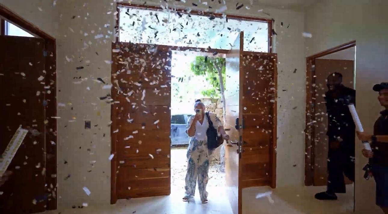 A client entering a villa through tall wooden doors