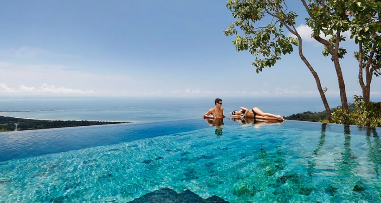 Couple in an infinity pool overlooking the ocean in Costa Rica