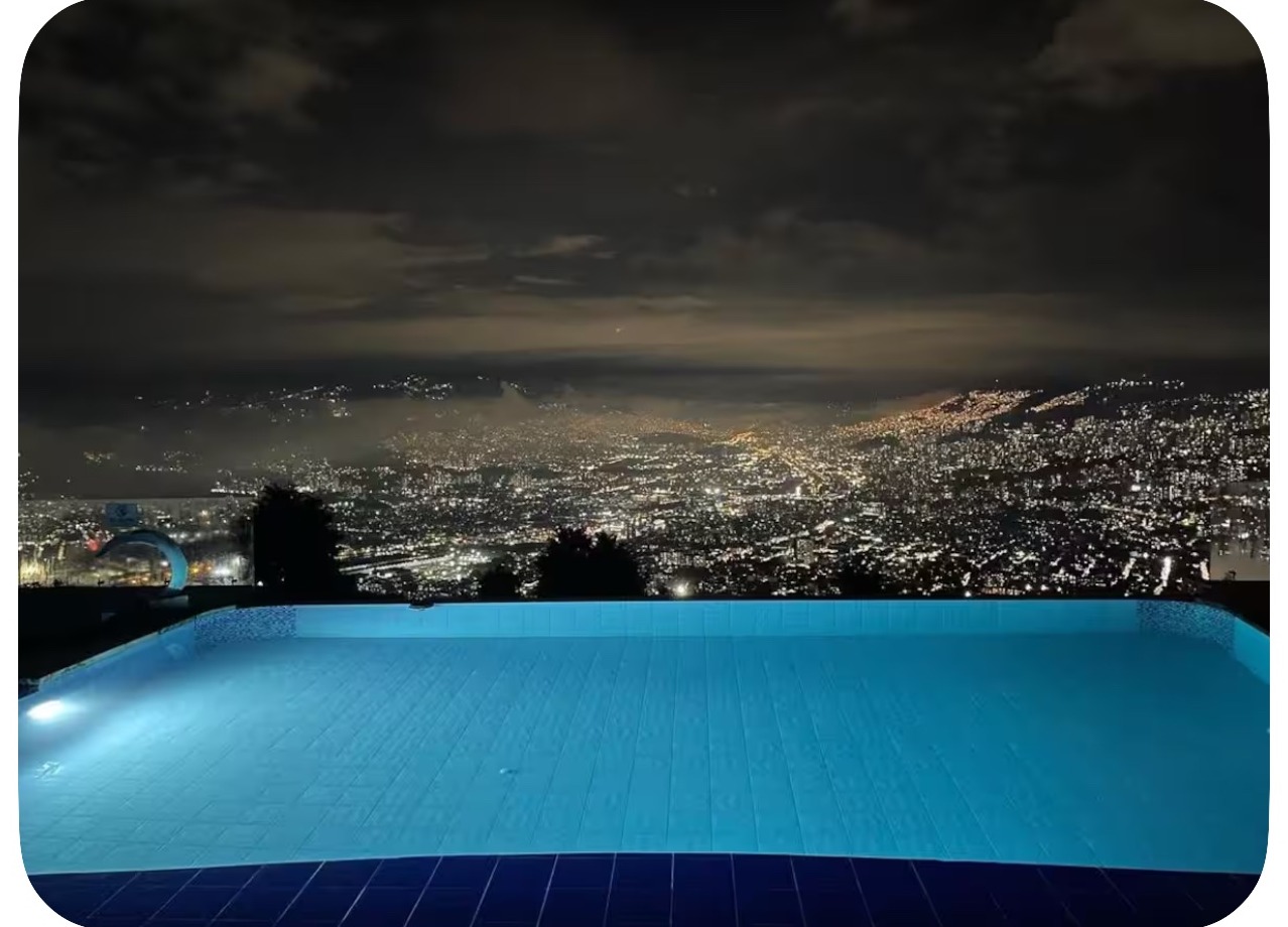 Heated pool at night with Medellín city lights at the seven-bedroom glass villa in Colombia