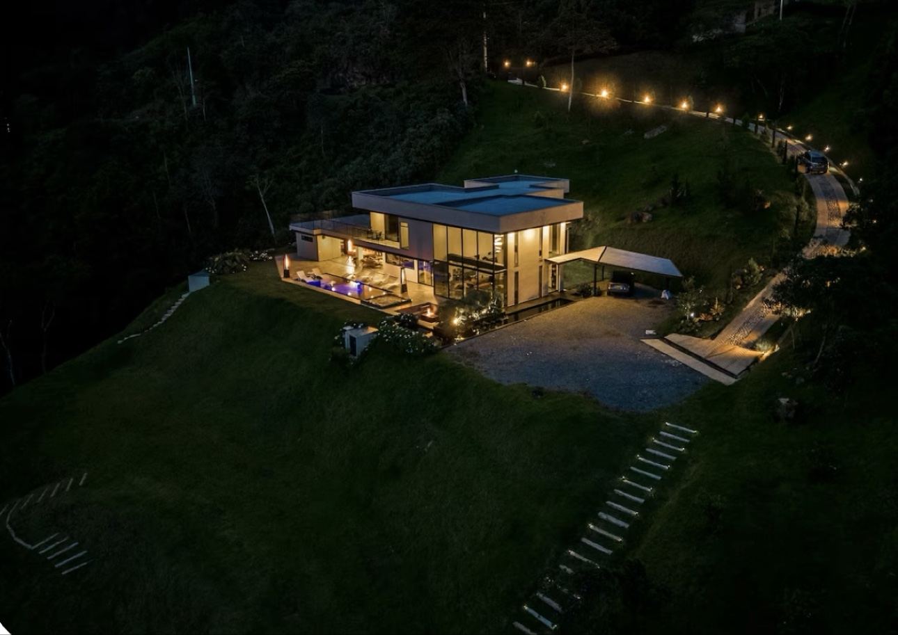 Five-bedroom private hillside villa glowing above Medellín, Colombia at night