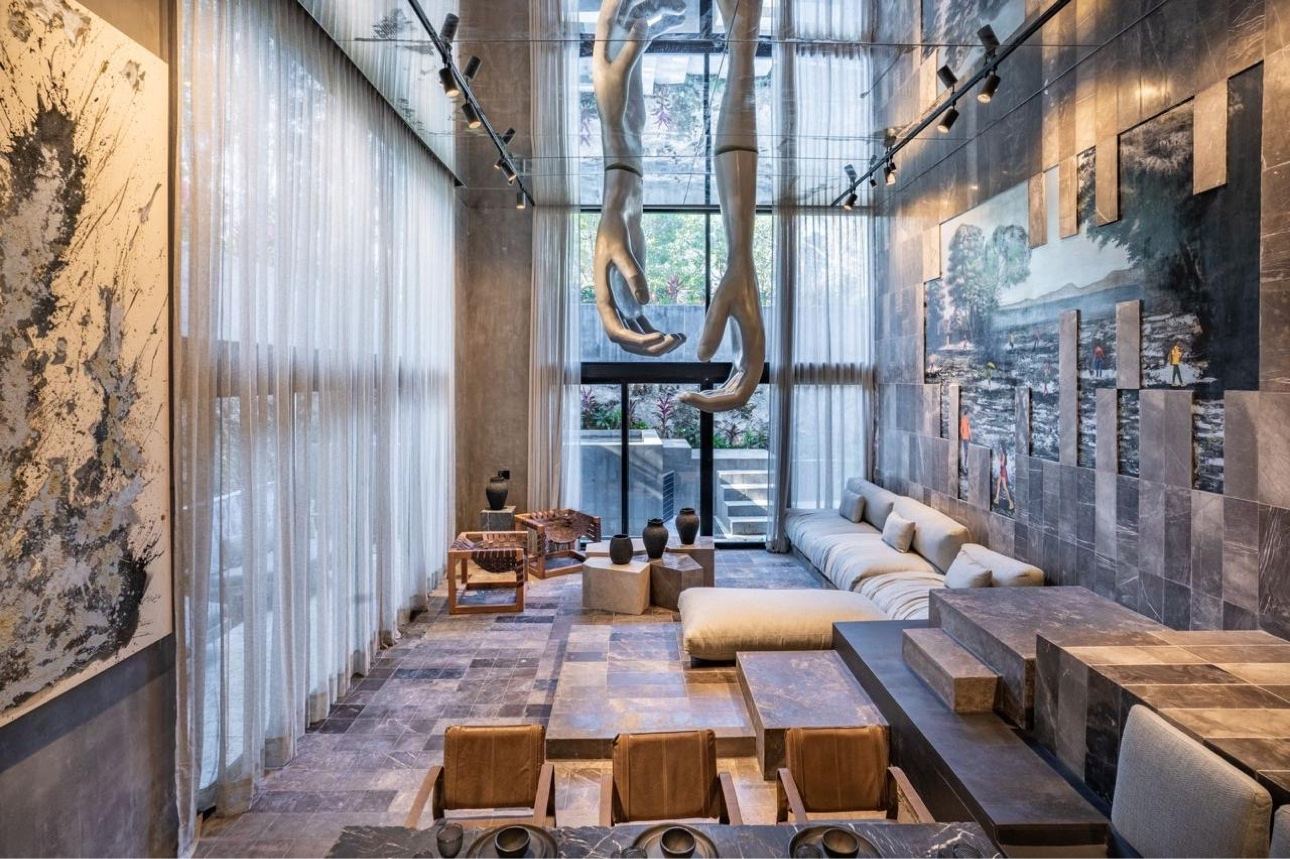 Dramatic living room with suspended hand sculptures in the Tulum beachfront villa